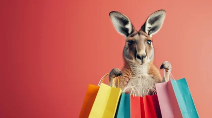 Poster Fashionforward kangaroo with a collection of trendy shopping bags slung over its shoulder, on a minimalist solid color backdrop © Jenjira