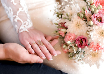 Hands of newlyweds with wedding rings	