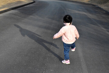 Fototapeta na wymiar A child playing with shadow 影で遊ぶ子供