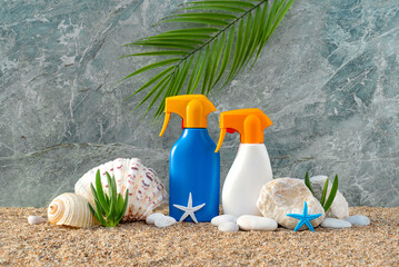 Spf. Bottles of sunscreen on the sand are decorated with seashells. UV protection. Body care. Grey...