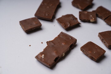 pieces of chocolate with raisins and nuts on a white table