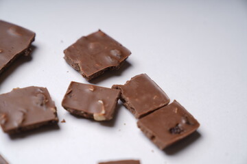 pieces of chocolate with raisins and nuts on a white table