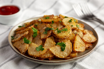 Homemade Roasted Garlic Parmesan Potatoes on a Plate, side view. Close-up.