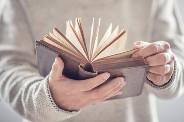 Man holding reading open book or holy bible - obrazy, fototapety, plakaty
