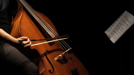 cellist playing cello under spotlight - obrazy, fototapety, plakaty