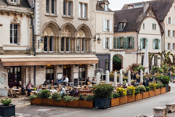 Fototapeta na wymiar Old street with old houses and tables of cafe in a small town Chartres, France