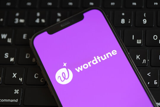 KYIV, UKRAINE - MARCH 17, 2024 Wordtune logo on iPhone display screen and MacBook keyboard. Artificial Intelligence engine