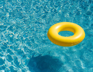 Yellow inflatable ring floating in blue swimming pool water, top view