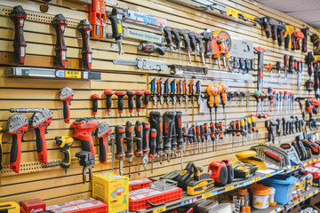 An assortment of hand tools and hardware displayed on a store wall, indicating a hardware store or home improvement section - obrazy, fototapety, plakaty