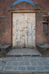 Fototapeta premium Old used wooden door in a red brick wall