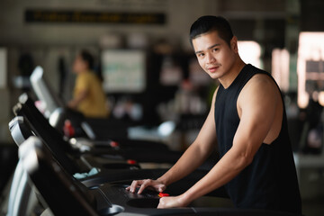 Asian athlete sport man runner touch start buttom before workout running on treadmill in fitness club. Cardio workout. Healthy lifestyle, guy training in gym. Sport running concept - obrazy, fototapety, plakaty