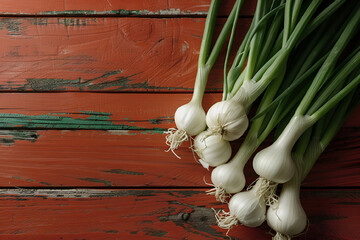 A bunch of fresh sweet garlic on a orange textured background. A hybrid of garlic and leek, a new...