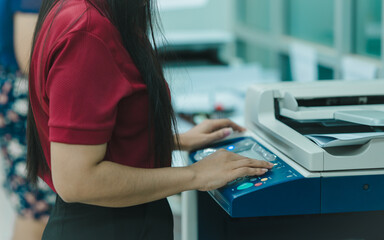 businesswoman is using a printer or Photocopier in office businesses, employees rely on advanced photocopier and printer technology as essential office equipment