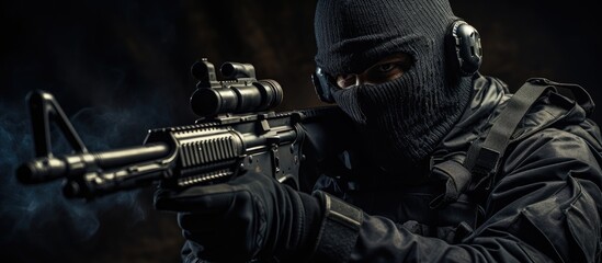 A man wearing a dark mask and jacket is standing while holding a firearm