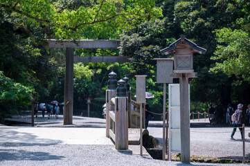wood bridge and Tori gate at The Grand Shrine of Ise or Ise Jingu Naiku, Inner Sanctuary in the natural green scenery background, Ise City, Mie., Japan