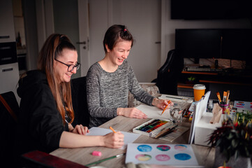 A heartwarming scene of two friends laughing and enjoying their artistic hobbies together at a...