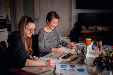 A heartwarming scene of two friends laughing and enjoying their artistic hobbies together at a...