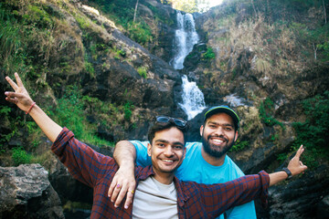 Group of travellers, tourist friends taking a selfie in front of Iruppu waterfalls in Coorg or...