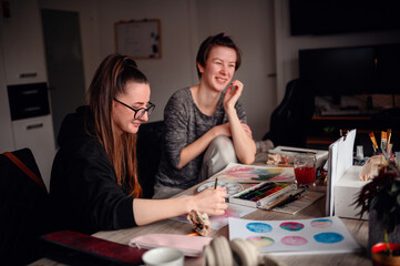 Fototapeta premium Two friends share a contemplative pause during an art-making session, exchanging ideas and enjoying the creative process together