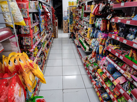Aisle with various kinds of goods on the shelves inside Alfamart (one of Indonesia local franchice Mini market business unit). selective Focus image.Bandung-Indonesia,March 22 2024