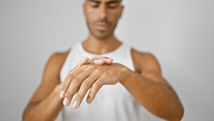 Hispanic man in white tanktop extends hands against isolated white background, implying a skincare...