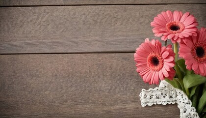 Bunch of gerber daisies on old wood with broderie ribbon