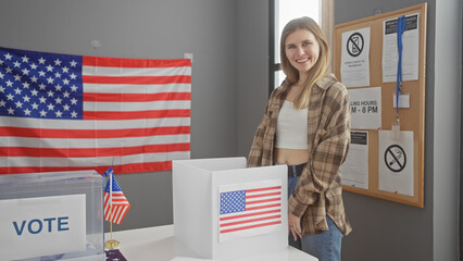 A young blonde woman smiles in a usa electoral college setting with voting booths, american flags,...