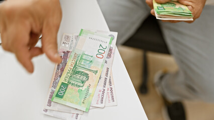 A close-up shot of a hand giving russian rubles currency at an office to signify a financial...