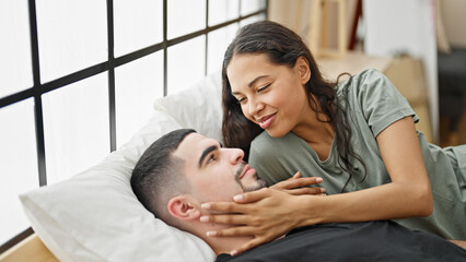 Happy love blooming in the beautiful couple's room as they enjoy a relaxed morning, lying in bed,...