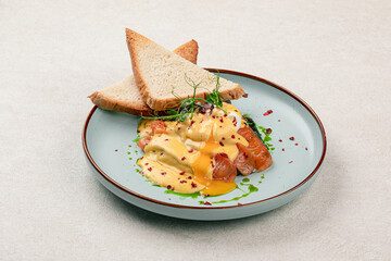 Portion of egg benedict with salmon and toasts