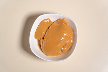 Bowl with sweetened condensed milk caramel sauce. Cooking Salted Caramel Chocolate Cold Cake Series.