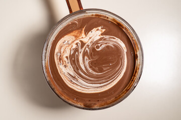 Making sauce with melting chocolate and thickened cream. Cooking Salted Caramel Chocolate Cold Cake Series.