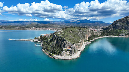 Aerial drone photo of iconic Acronafplia fortress overlooking old city of Nafplio below famous castle of Palamidi as seen in a spring morning with beautiful clouds and deep blue sky, Argolida, Greece - obrazy, fototapety, plakaty