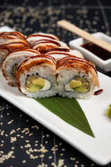 Golden dragon sushi roll with tuna, eel, cucumber, sesame seeds and tobiko caviar