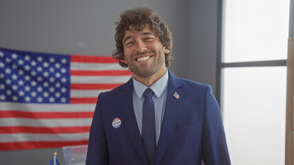 Young hispanic man smiling indoors with american flag background donning a suit and 'i voted'...