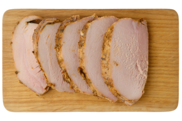Sliced baked pork fillet on wooden cutting board