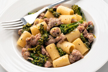 Piatto di deliziose mezze maniche condite con salsa di broccoli e salsiccia, pasta italiana, cibo...