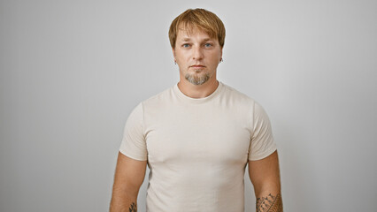 Portrait of a young, caucasian, bearded, blond man with tattoos isolated on a white background.