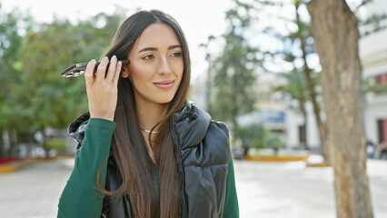 Woman listening voicemail outdoors in the city.
