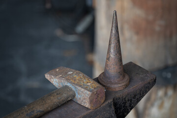 Anvil with hammers in a forge with a mandrel. - obrazy, fototapety, plakaty