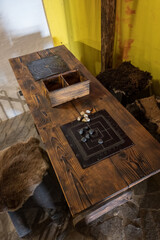 A leather board with a turn-based game placed on a wooden table.