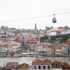 View of Porto, Portugal old town on the Douro River, with a cable car above the city