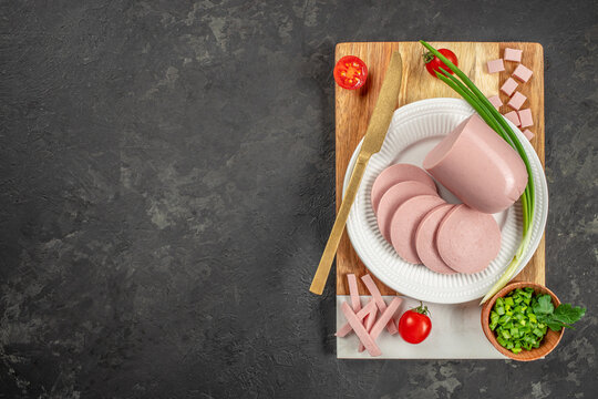 Sliced boiled ham sausage on a dark background. top view. copy space for text