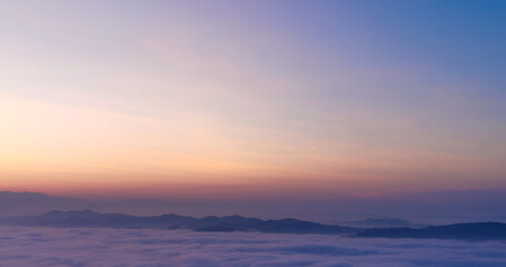 Un mare di nebbia e nuvole al tramonto riempie le valli sotto le montagne