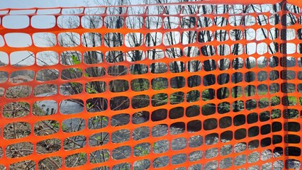 Recinzione da cantiere in rete di plastica arancione.