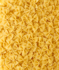 Italian Pasta Farfalle Background. Uncooked Bow Tie Pasta Close-up. Food Creative Concept. Top view, directly above.