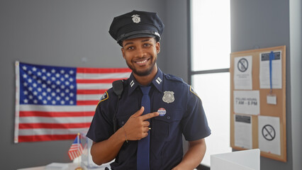 African american police officer with friendly smile flashing i voted sticker in front of us flag...
