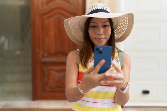Young asian woman tourist smiling confident using smartphone at street