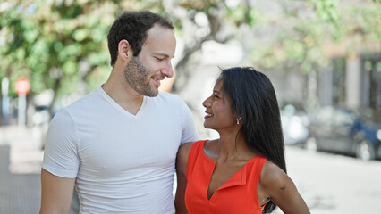 Obraz premium Beautiful couple smiling confident hugging each other at street