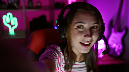 A young woman enjoying her time in a vibrant gaming room at night, radiating positive energy.